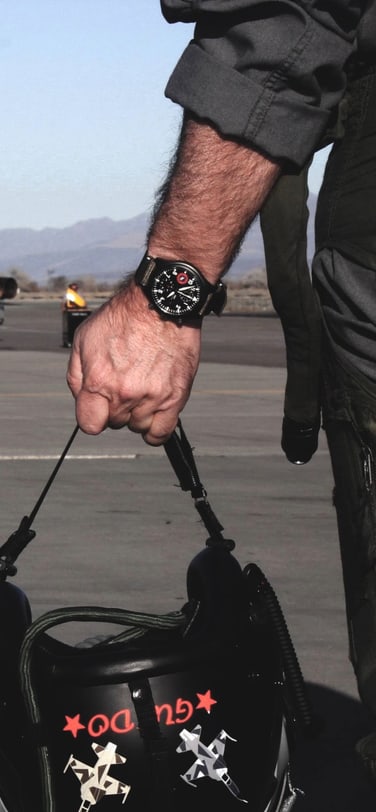 A TOPGUN pilot holding their helmet with an IWC watch