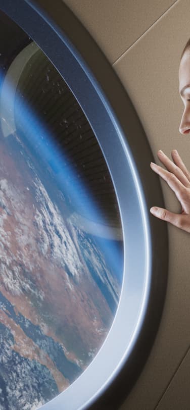 一名女性宇航员从太空站窗口望向地球表面。