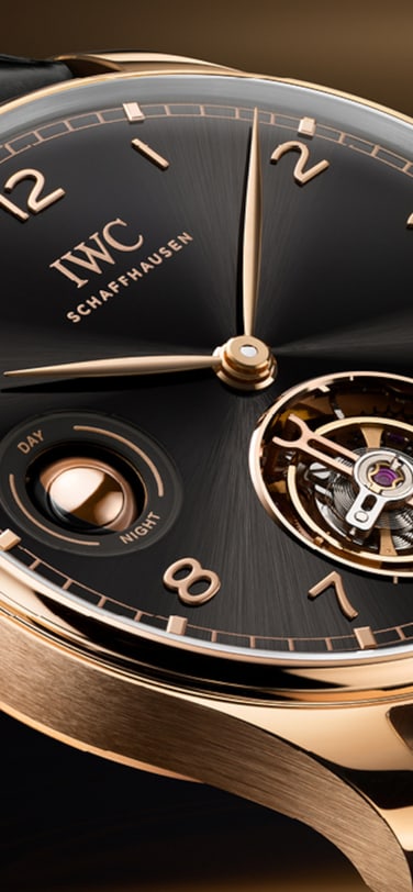 IWC葡萄牙系列手动上链陀飞轮昼夜显示腕表,搭载曜石黑表盘、18K Armor Gold®硬金表壳和Santoni黑色鳄鱼皮表带。