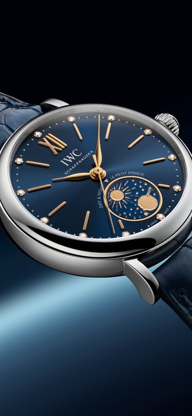 以宇宙为灵感的背景前，皮表带上蓝色表盘和昼夜显示的IWC 柏涛菲诺自动腕表昼夜显示34 小王子