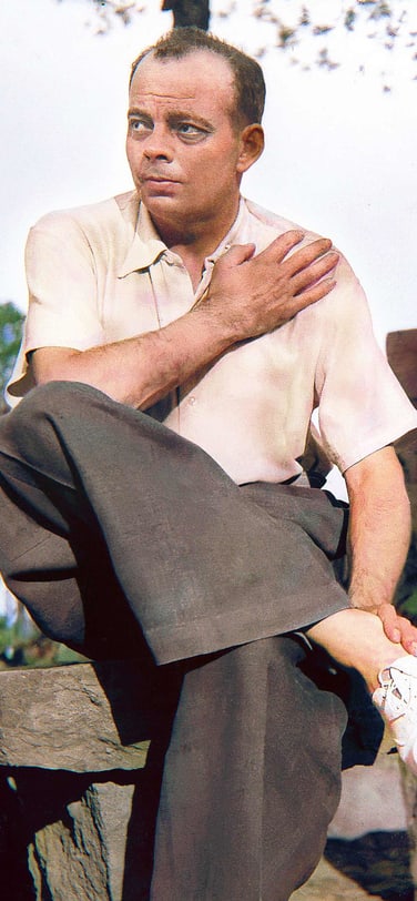 Color photo of Antoine de Saint-Exupéry sitting in the sun