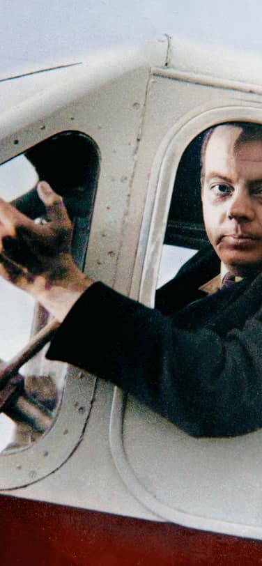 Antoine de Saint-Exupéry waving from the window of a small plane