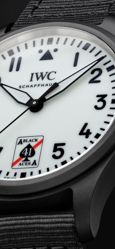 Close up of the Pilot's Watch Automatic 41 Black Aces case and strap, white dial with black numbers and in place of 6'o'clock, features a stylized Ace of spades logo withred strip and number 41