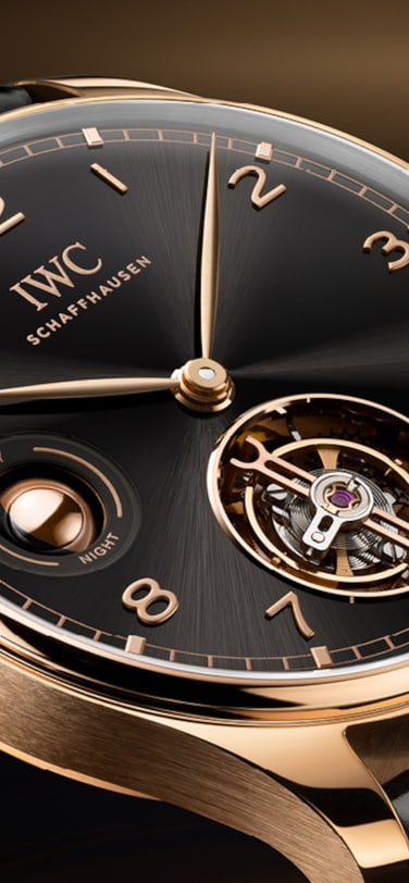 IWC葡萄牙系列手动上链陀飞轮昼夜显示腕表,搭载黑色表盘、18K Armor Gold®硬金表壳和Santoni黑色鳄鱼皮表带