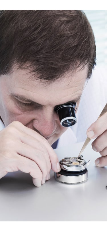 An IWC watchmaker working with fine equipment