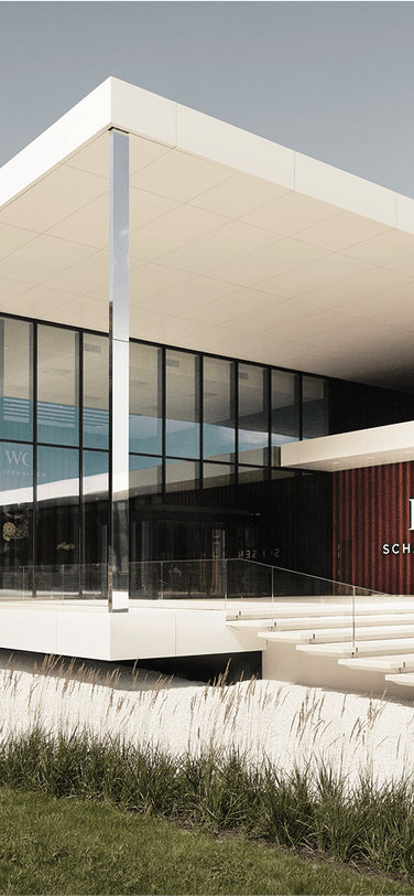 IWC headquarters with an elegant sleek building surrounded by greenery