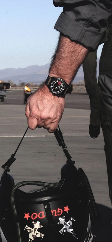 一位TOPGUN飞行员手持头盔，佩戴IWC万国表腕表