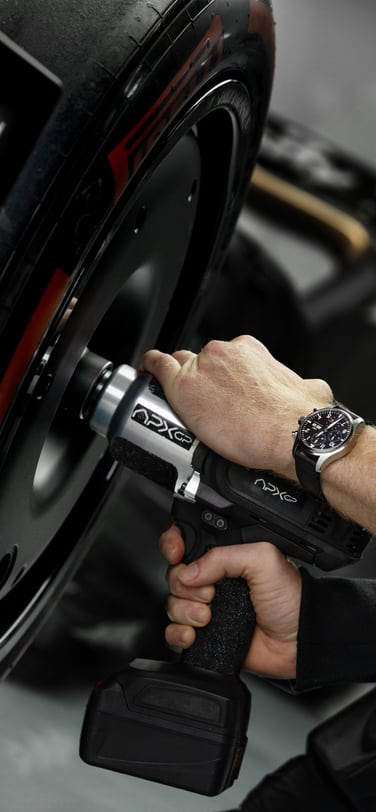 Closeup shot of a wheel gun operator’s wrist changing tires of a formula one car