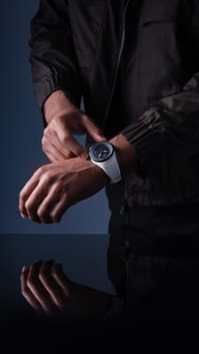 一名男性手腕上的Pilot's Venturer Vertical Drive；白色表壳和表带、黑色表圈的太空认证机械腕表。