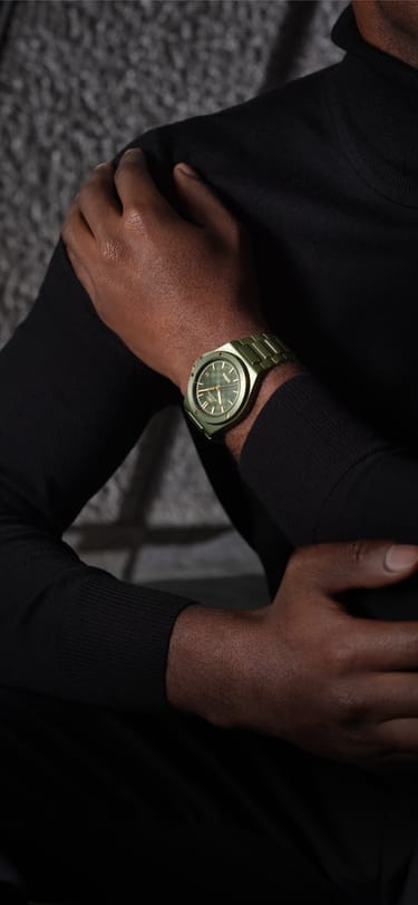 暖光环境下佩戴IWC 工程师系列腕表的深色高领毛衣人物手腕特写