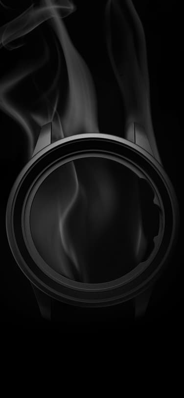 艺术拍摄：黑色背景上的 IWC 葡萄牙系列 Ceratanium® 黑色表壳；烟雾自原本表盘位置升起。