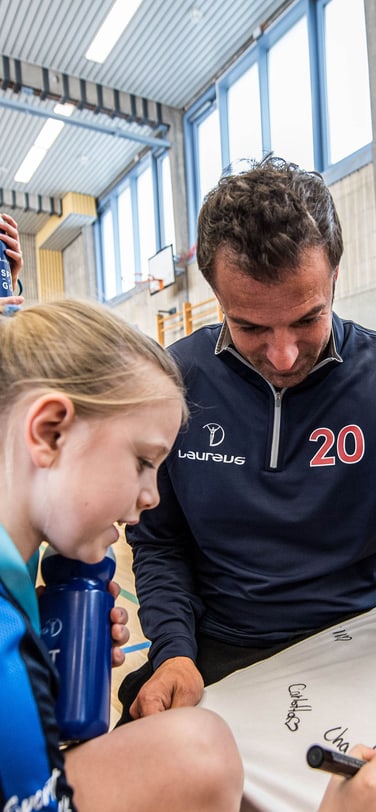 Laureus sport for good participants signing a t-shirt.