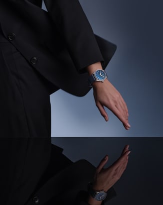 深色西装人物就坐，手腕上IWC腕表清晰可见