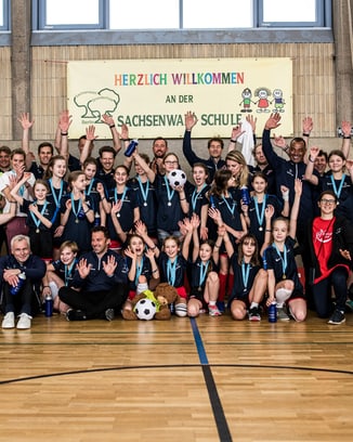Participants of a Laureus Academy event posing together in a large group photo.